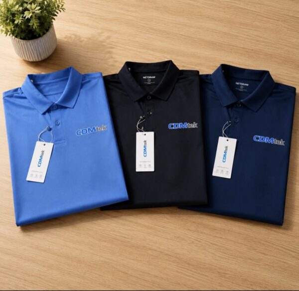 Blue, black and navy polo shirts with embroidered chest logos displayed on a wooden table